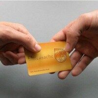 Die Mettingen Ehrenamtskarte Eine Hand reicht einer anderen Hand eine goldene Visitenkarte mit dem Schriftzug